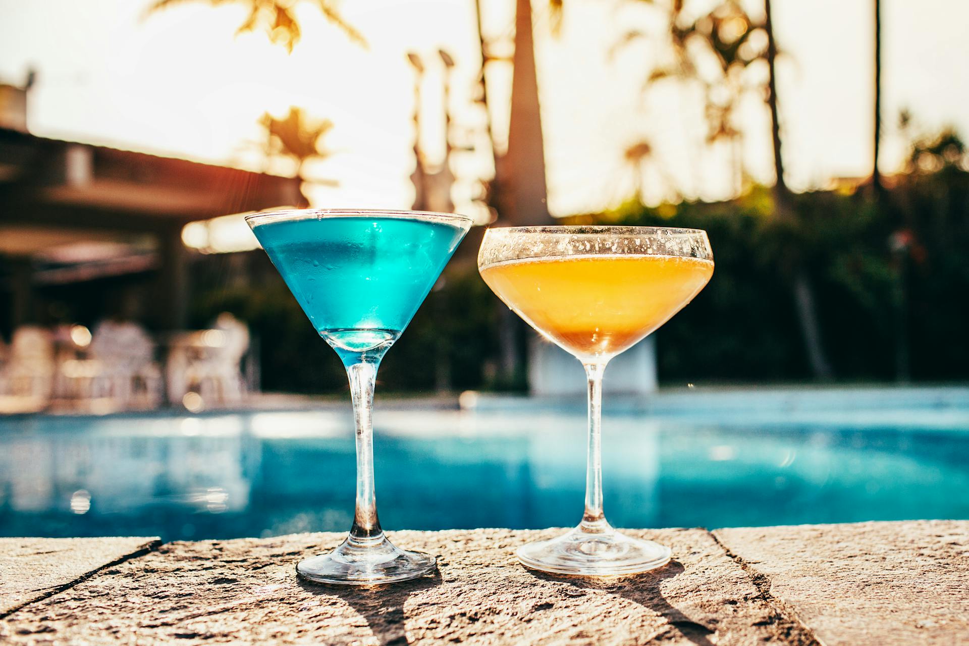 A vibrant poolside cocktail scene at sunset, summer in a Midwest backyard.